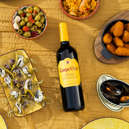 Bottle of Campo Viejo wine surrounded by tapas on a wooden table
