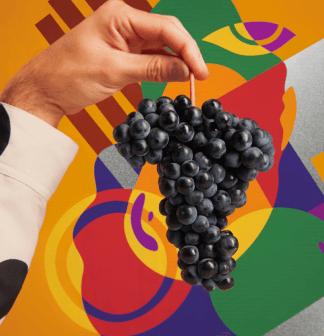 Bunch of grapes held by a hand against a colorful abstract background